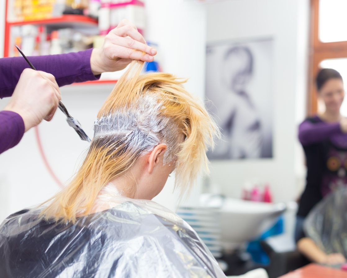 Hairdresser salon. Woman during hair dye.